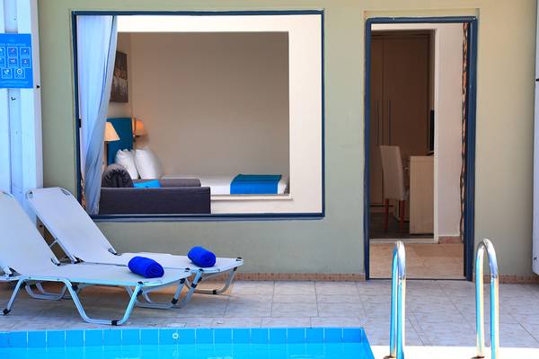 Lounge-Bereich des Blue Bay Beach Resort mit Blick auf ein Schlafzimmer und einen Pool.