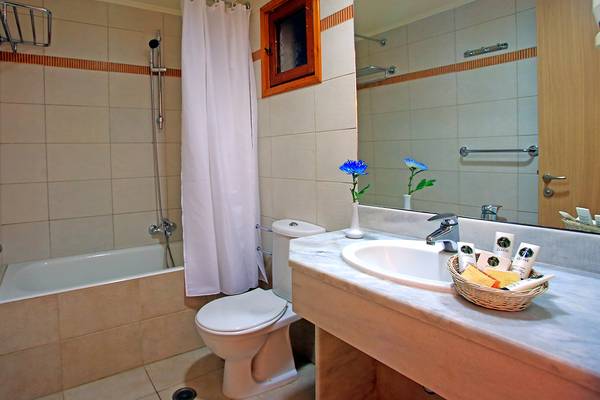 Badezimmer des Blue Bay Beach Resort mit Badewanne, Toilette und Waschbecken.