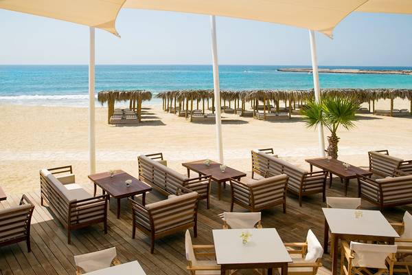 Außenbereich des Asterias Beach Hotels mit Blick auf den Strand und das Meer.