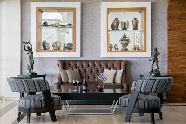 Lobby-Lounge des Asterias Beach Hotels mit Möbeln, Vasen und Statuen.