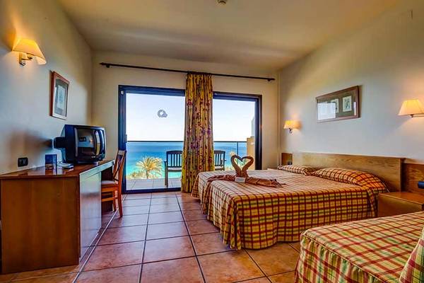 Hotelzimmer im SBH Club Paraiso Playa mit Meerblick, zwei Betten und einem Schreibtisch.