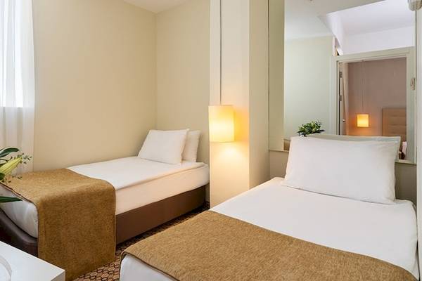 Doppelzimmer im Crystal Centro Resort mit zwei Betten, einem Tisch und einer Couch.