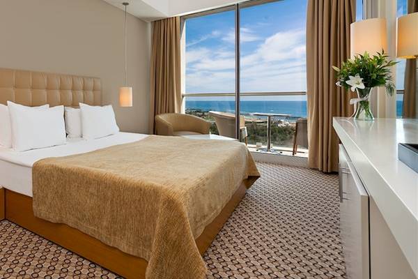 Hotelzimmer im Crystal Centro Resort mit Meerblick, inklusive Bett, Fenster und Balkon.