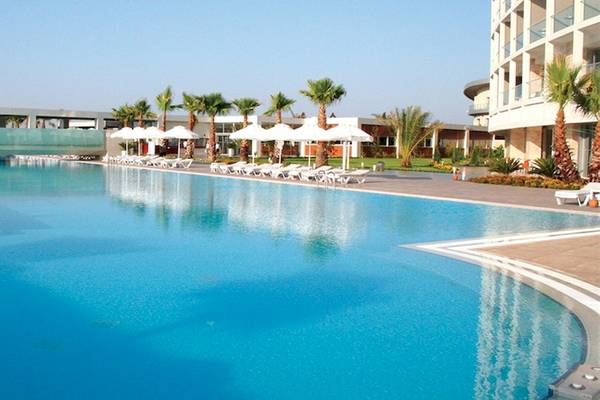 Außenpoolbereich des Crystal Centro Resorts mit Sonnenliegen und Palmen