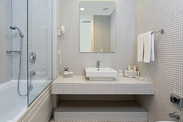 Badezimmer im Crystal Centro Resort mit Badewanne, Dusche, Spiegel und Waschbecken.