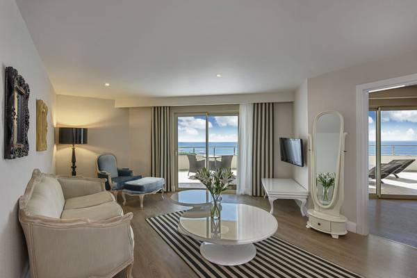 Wohnbereich der Delphin Imperial Suite mit Blick auf das Meer und einem modernen Innendesign.