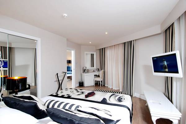 Schlafzimmer im Delphin Imperial Hotel mit Bett, Fernseher, Schreibtisch und Lampe