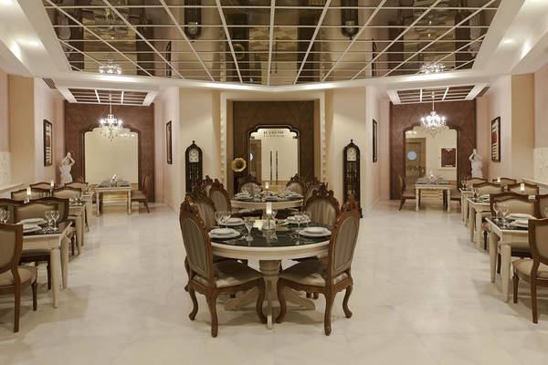 Innenansicht des Restaurants im Delphin Imperial Hotel mit runden Tischen und Stühlen.