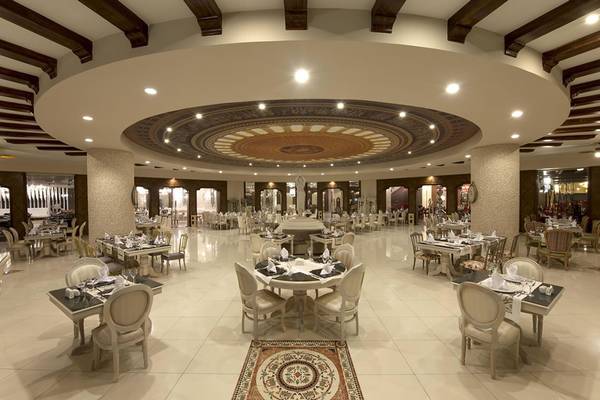 Innenansicht des Restaurants im Delphin Imperial Hotel mit runden Tischen und Stühlen.