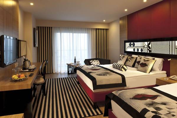 Doppelbett-Zimmer im Delphin Imperial Hotel mit zwei Betten, Dekor, Fenster und Fernseher.