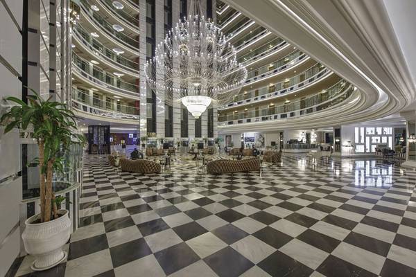 Lobby des Delphin Imperial Hotels mit einer großen Kristallkronleuchter und schwarzen und weißen Bodenfliesen