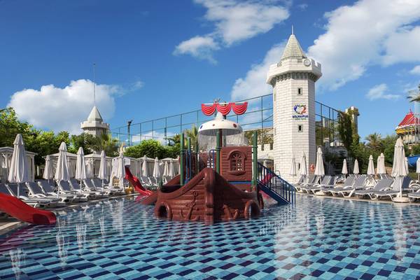 Außenansicht des Delphin Imperial Wasserparks mit einem Boot-Spielplatz im Pool.