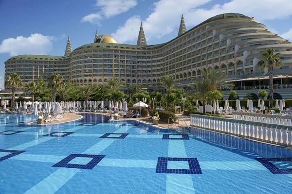 Außenbereich des Delphin Imperial Hotels mit Swimmingpool und Sonnenliegen.