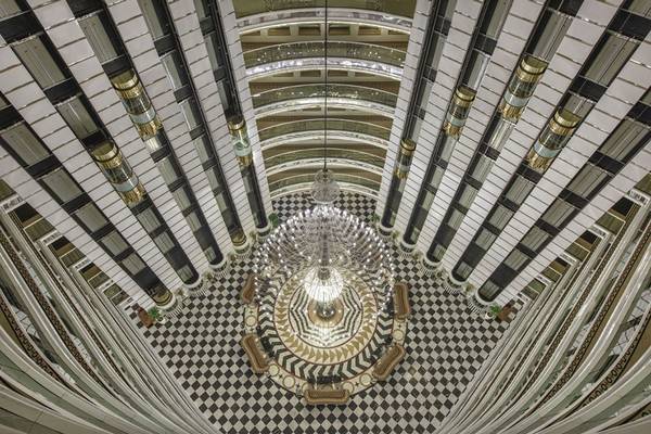 Ansicht von oben des Delphin Imperial Hotel-Lobbys mit zentralem Kronleuchter und schwarzen und weißen Bodenfliesen.