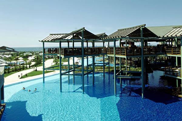 Luftaufnahme des Schwimmbads im Limak Lara De Luxe Hotel & Resort mit Personen und Gebäuden