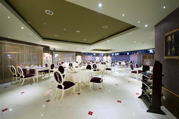 Innenansicht des Restaurants im Limak Lara De Luxe Hotel & Resort mit gedeckten Tischen und Stühlen.