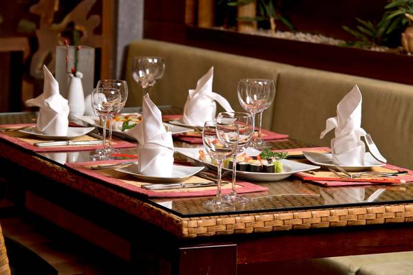 Tisch im Restaurant mit Speisen und Getränkegläsern, Servietten und Besteck.