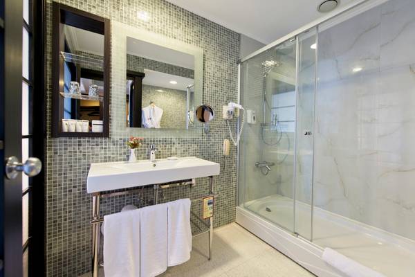 Badezimmer im Limak Lara De Luxe Hotel mit Dusche und Waschbecken.