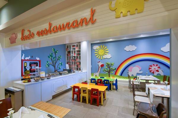 Kinderrestaurant im Limak Lara De Luxe Hotel & Resort mit bunten Wandmalereien und farbenfrohen Tischen und Stühlen.