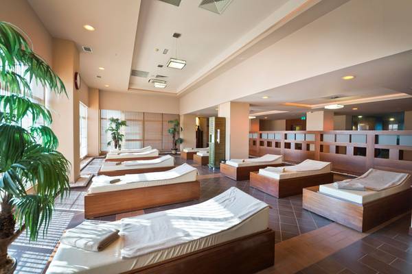 Saunabereich im Limak Lara De Luxe Hotel & Resort mit mehreren Liegen und Pflanzen.