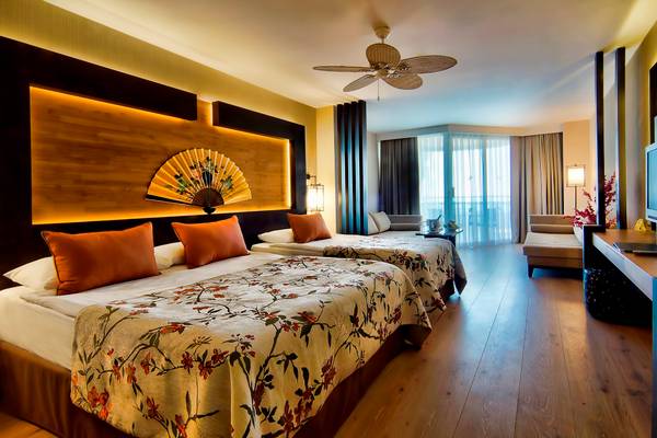 Zwei Betten in einem stilvollen Hotelzimmer von Limak Lara De Luxe Hotel & Resort