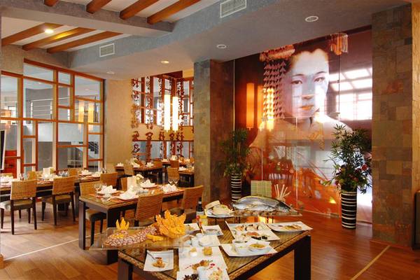 Innenansicht eines Hotels mit Restaurant, Tisch mit Sushi, große Wandmalerei einer Dame.