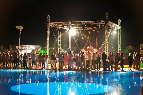 Eine nächtliche Pool-Party im Limak Lara De Luxe Hotel & Resort mit vielen Gästen und einer Bühne im Pool.