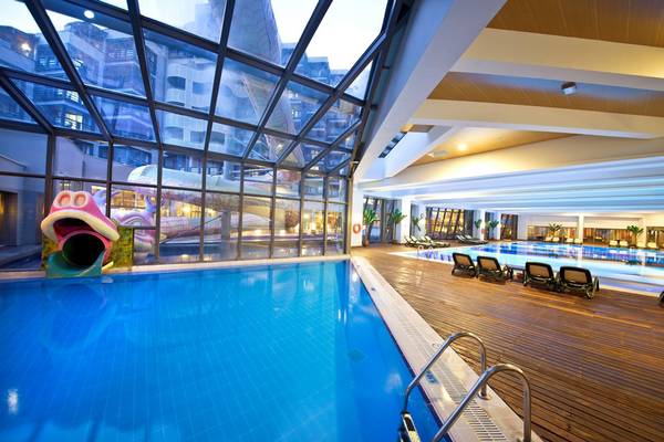 Das beheizte Hallenbad im Limak Lara De Luxe Hotel mit Rutsche und Liegebereichen.