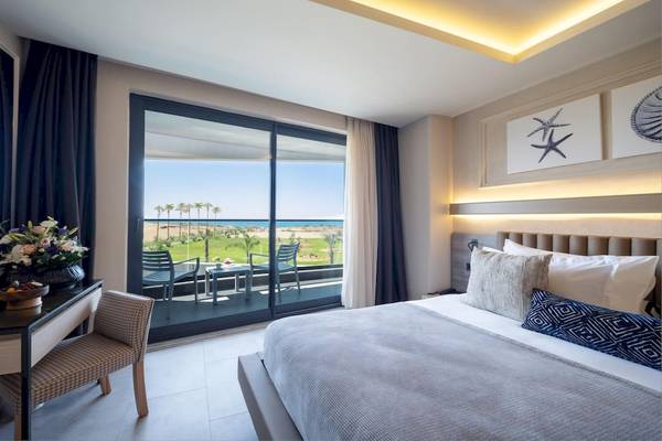 Ein elegantes Zimmer im Liu Resorts mit einem großen Fenster, das auf den Strand und das Meer hinausblickt.