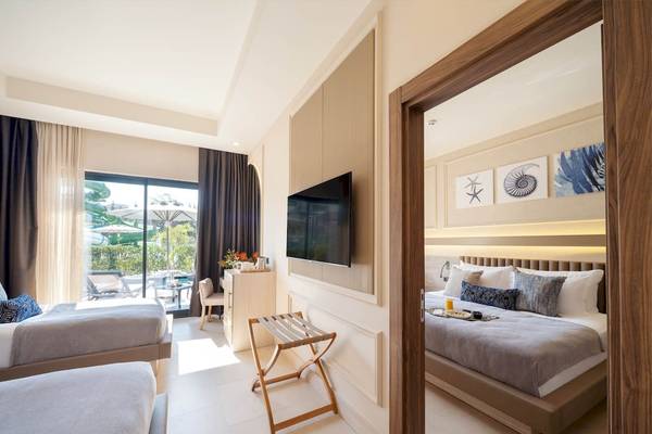 Hotelzimmer von Liu Resorts mit zwei Doppelbetten, Fernseher und Blick auf den Garten