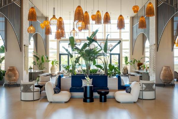 Innenansicht der Lobby von Liu Resorts mit blauen Sofas, weißen Sesseln, Pflanzen und Hängelampen.