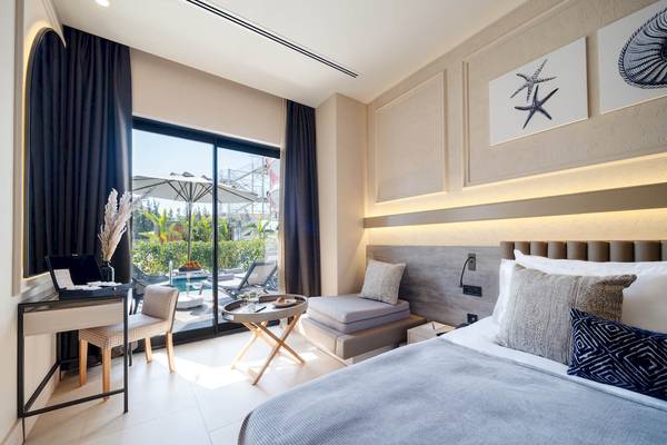 Hotelzimmer von Liu Resorts mit Doppelbett, kleiner Sitzecke und Aussicht auf einen Pool.