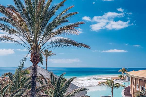 Ausblick auf das Iberostar Selection Fuerteventura Palace Hotel mit Palmen und Meer im Hintergrund.
