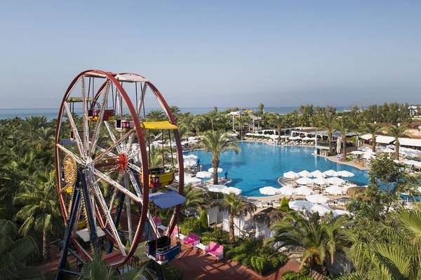 Luftaufnahme des Delphin Palace Hotels mit einem Riesenrad und einem großen Pool.