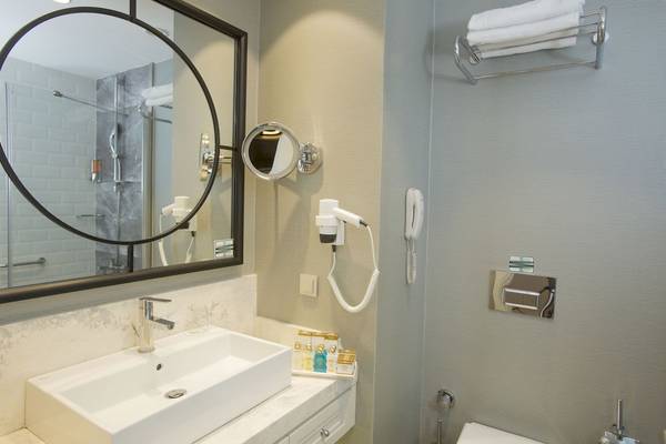 Badezimmer von Fame Residence Kemer & Spa mit Waschbecken, Spiegel und Toilette.