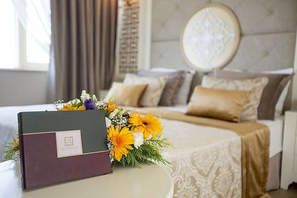 Fame Residence Zimmer mit Blumen und Geschenk auf dem Bett