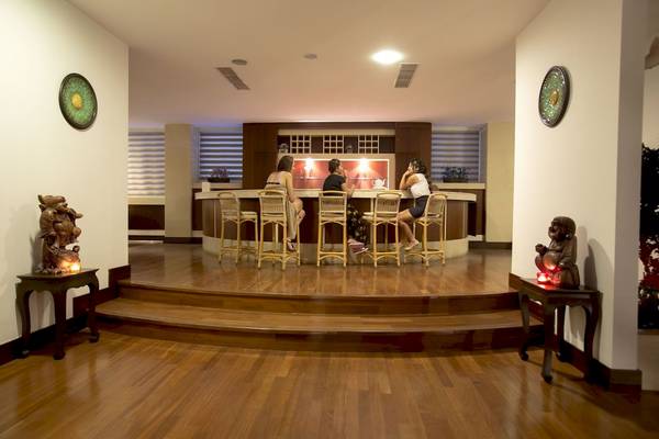 Barbereich des Fame Residence Kemer & Spa Hotels mit Personen, die an der Theke sitzen.