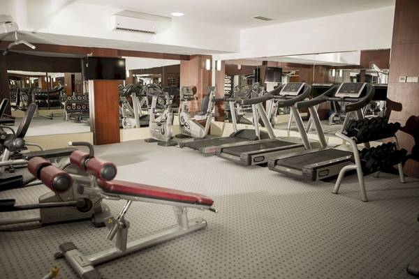 Fitnessstudio im Fame Residence Kemer & Spa mit Laufbändern, Hanteln und Trainingsgeräten.