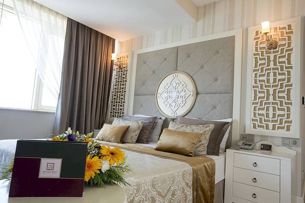 Fame Residence Kemer Zimmer mit einem Bett, Blumen und einer Aussicht auf die Stadt.