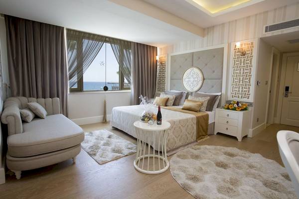 Suite Zimmer im Fame Residence Kemer & Spa mit Meerblick, Bett, Nachttisch und Loungebereich.