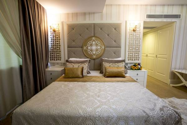 Schlafzimmer im Fame Residence Kemer mit elegantem Bett und Dekor