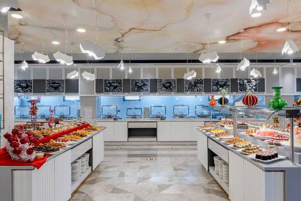 Buffetbereich im Fame Residence Kemer & Spa Hotel mit verschiedenen Gerichten und einer farbenfrohen Decke.