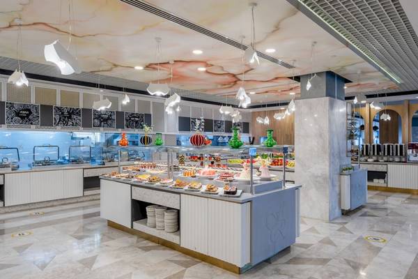 Buffet-Tisch im Fame Residence Kemer & Spa Hotelrestaurant mit verschiedenen Speisen und Kuchen.