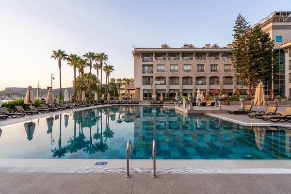 Außenpool des Fame Residence Kemer & Spa Hotels mit Sonnenliegen und Palmen
