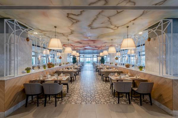 Innenansicht des Restaurants im Fame Residence Kemer & Spa mit geometrischen Mustern, Tischen und Stühlen.