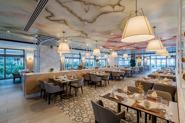 Innenansicht des Restaurants im Fame Residence Hotel & Spa mit gedeckten Tischen und farbiger Deckengestaltung.