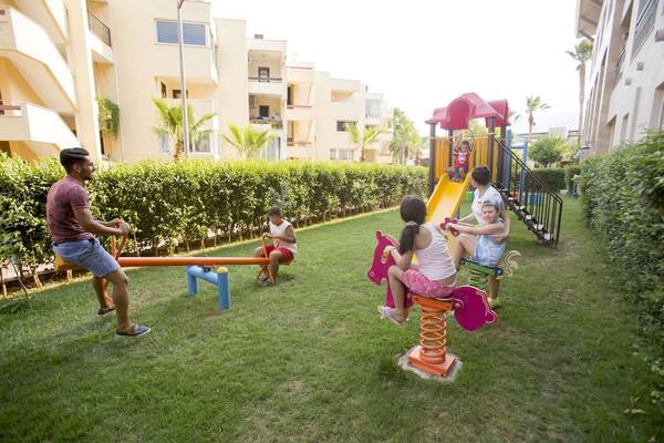 Kinder spielen auf einem Spielplatz im Fame Residence Kemer & Spa Hotel.