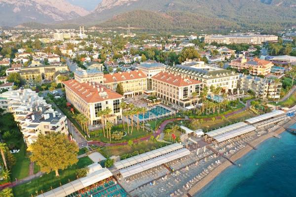 Luftaufnahme des Fame Residence Kemer & Spa Hotels mit Swimmingpool, Strand und Bergpanorama.