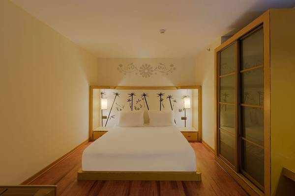 Schlafzimmer im Siam Elegance Hotel & Spa mit Doppelbett, Wanddekoration und beleuchteten Nachttischen