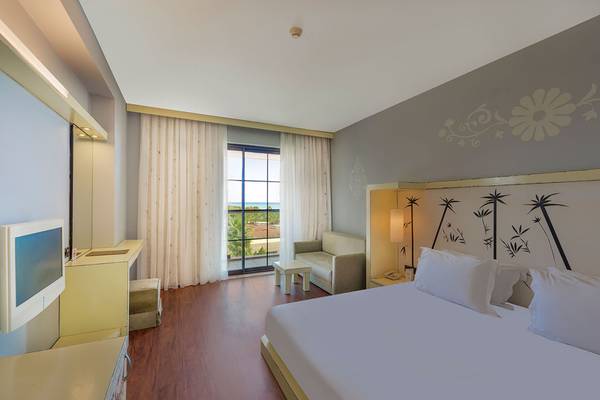 Schlafzimmer im Siam Elegance Hotels & Spa mit einem großen Bett, Fenstern und einem Ausblick auf den Ozean.